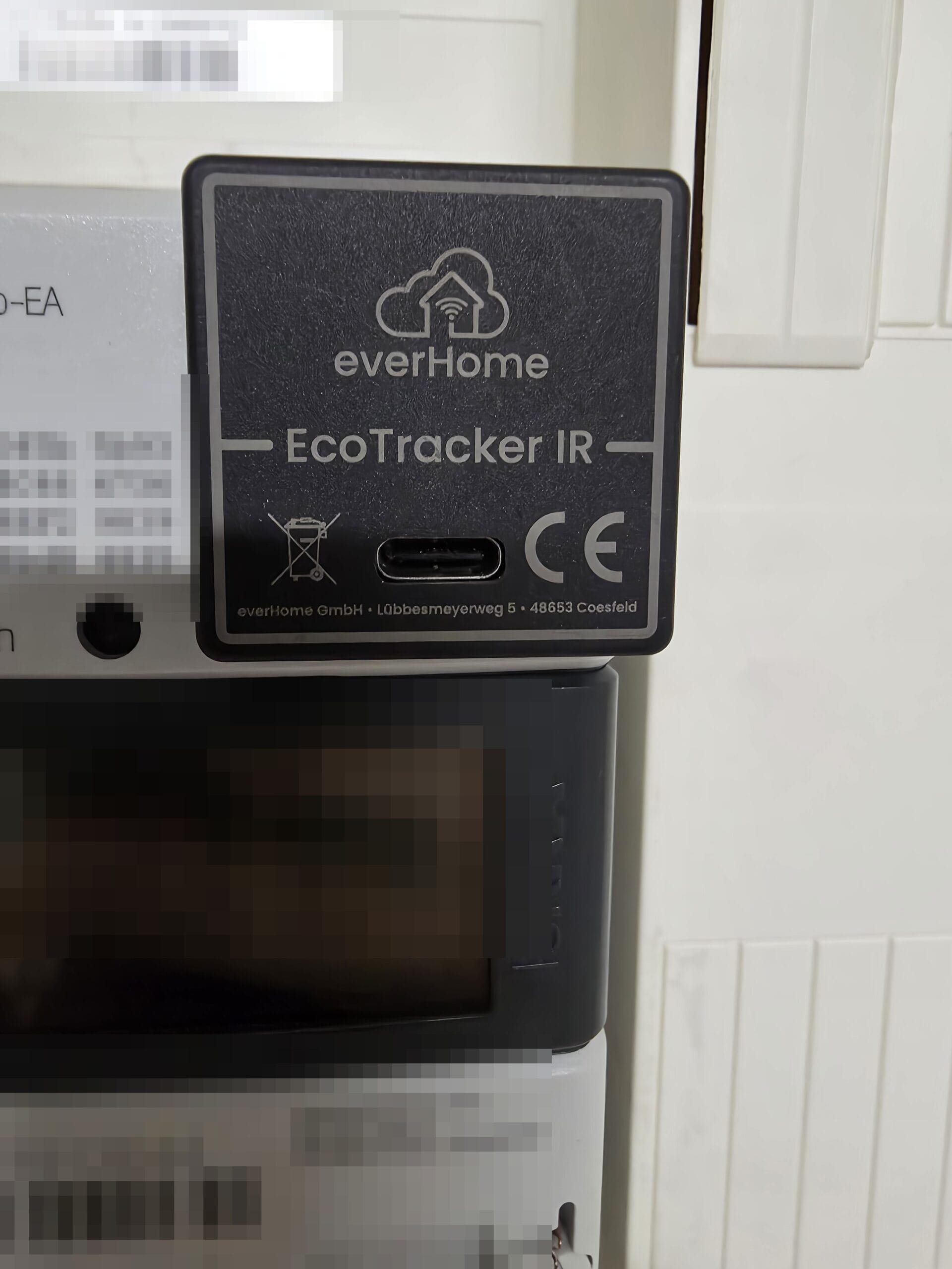Nahaufnahme des everHome EcoTracker IR mit USB-C-Anschluss, magnetisch auf der optischen Schnittstelle des Stromzählers befestigt
