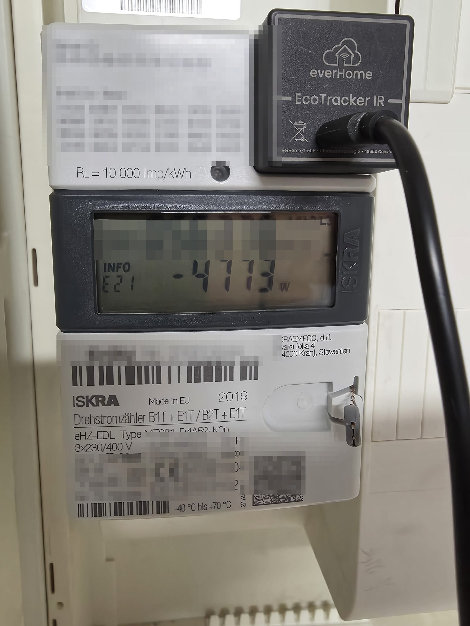 everHome EcoTracker IR auf der optischen Schnittstelle eines Iskra-MT681-Stromzählers, das Display zeigt eine Momentanleistung von minus 4.773 Watt bei Netzeinspeisung